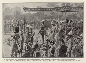 O desfile das tropas coloniais no Palácio de Buckingham pelo rei, Sua Majestade, retornando a saudação